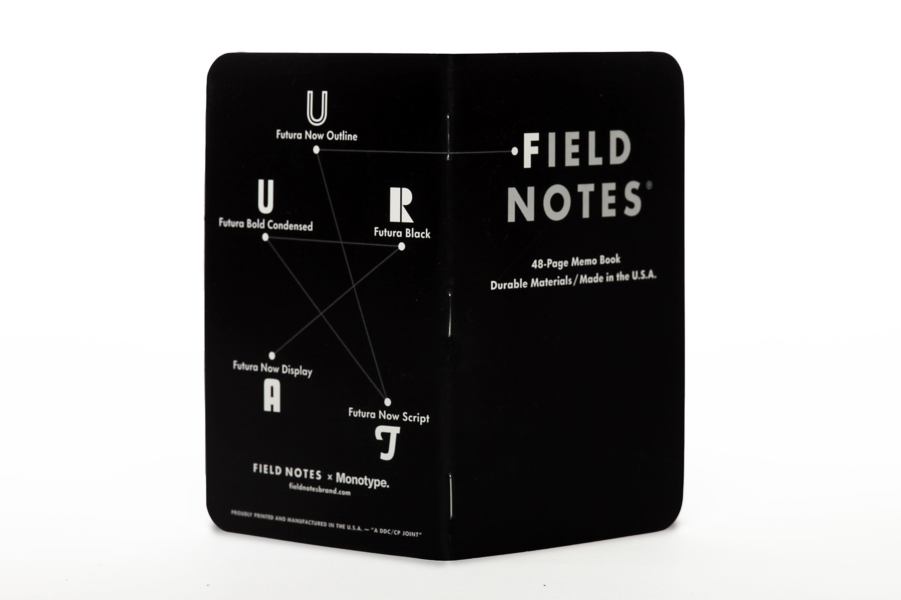 An image of the Field Notes x Monotype notebook collaboration for Adobe MAX. Black notebook with white text. The back includes typographic constellations with the typeface listed below each character.