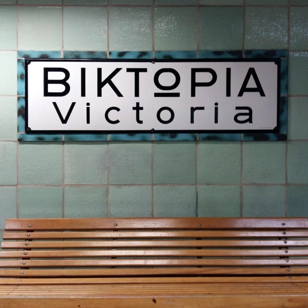 BIKTOPIA Victoria sign in tile above a wooden bench.