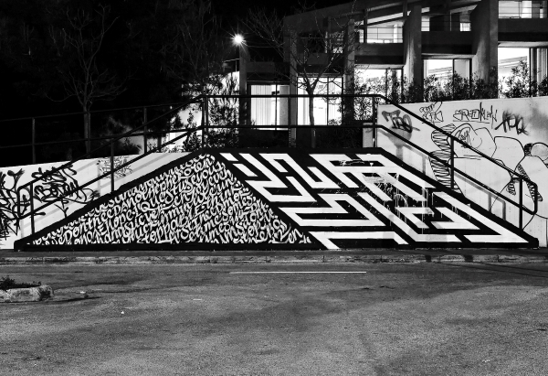 Black and white image of street art on an incline in Athens.