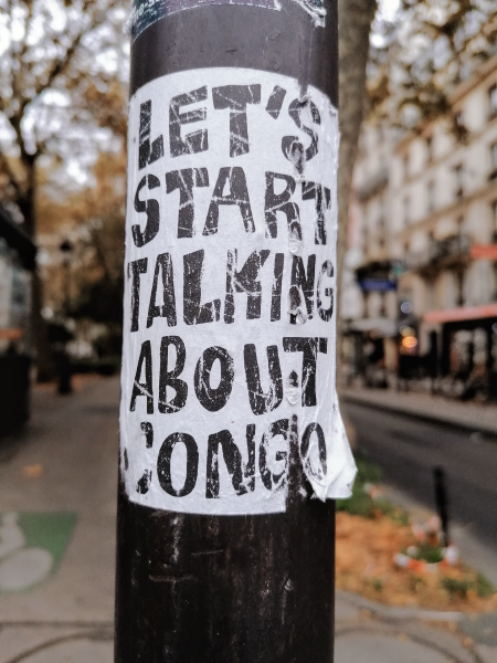 Hand lettered street flyer in Paris. Text: "Let's start talking about Congo" in all caps, black and white.