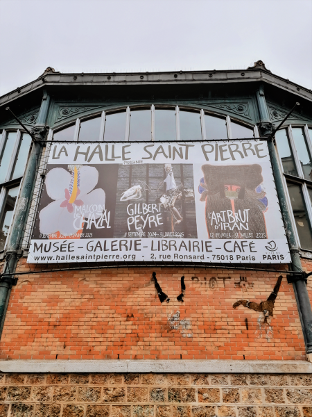 Billboard for La Halle Saint Pierre, with name in handwritten font in all caps.