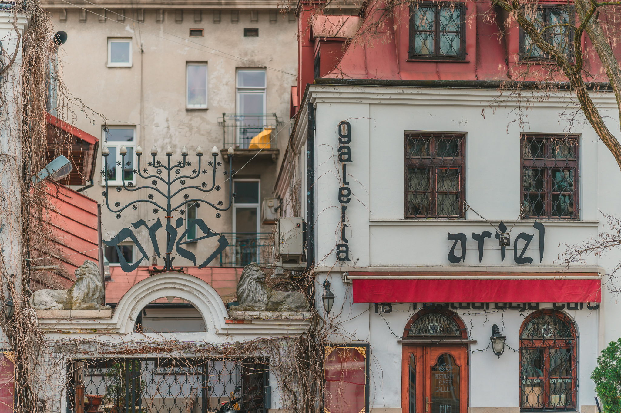 Buildings in Kazimierz in Kraków. The historic buildings are in layers, with signs featuring a variety of typefaces and styles.