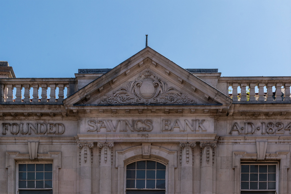 The current Stockport Savings Bank building. Stone building built in the early 20th century. Text carved in relief: "FOUNDED - SAVINGS BANK - A·D·1824"