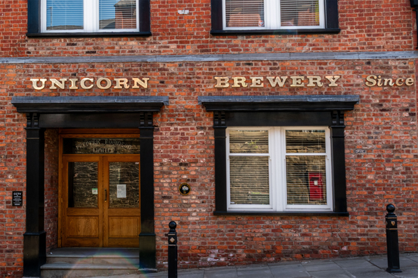 Brick building holding Unicorn Brewery. Text in gold letters attached to the brick: "UNICORN BREWERY SINCE"