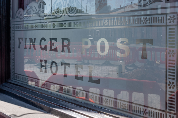 Window in Stockport, UK. Frosted white background with see-through lettering: "FINGER POST HOTEL"