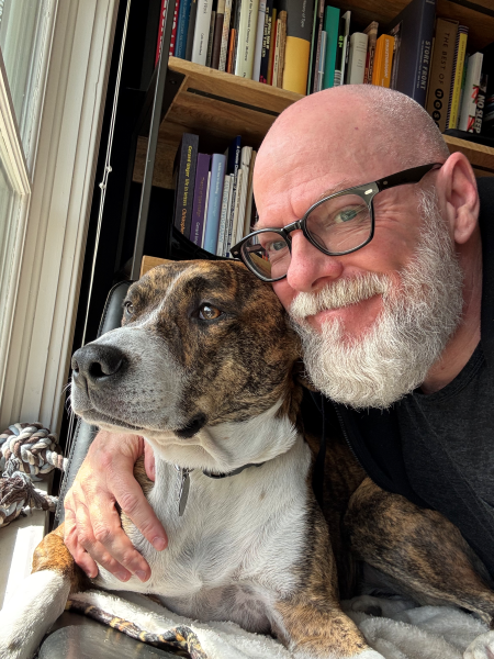 Dan at home with BB the dog and his books.