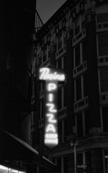 Nighttime black and white photo of Regina Pizza neon sign. Photo by Jake Murtaugh.
