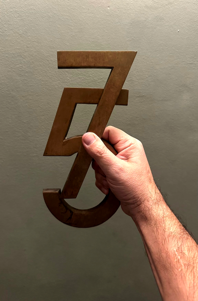 Hand-sized metal 7 and 5 held in one hand. Photo by Giuseppe Salerno.