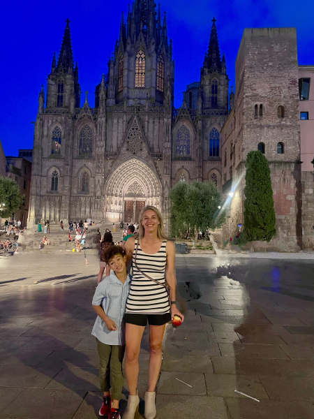 Kristin Ratzlaff and son in Barcelona, posing in front of a historic building.