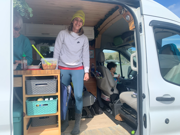 Inside Kristin Ratzlaff's travel van. Kristin pictured, smiling.
