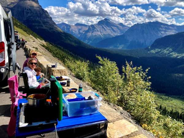 Kristin Ratzlaff and crew take a break outside her van with a beautiful view of the mountains.