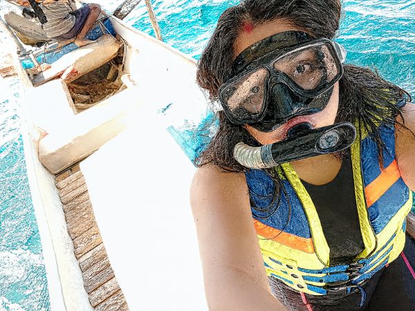 A selfie of Sneha on a boat, getting ready to snorkel.