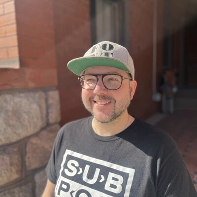 Portrait of Phil Carey-Bergren standing outside in the sun.