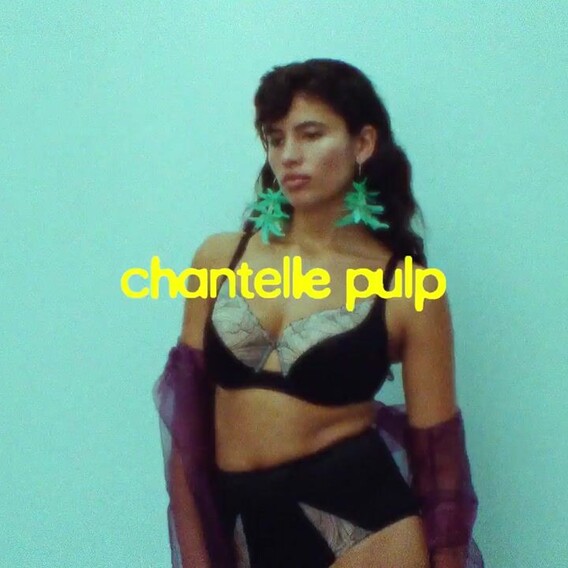Model in black lingerie against a turquoise background, with the 