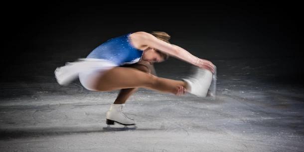 A figure skater in movement on the ice.