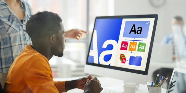 Professional creative working at a screen examining font choices.